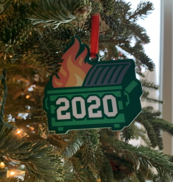 "An ornament on a Christmas tree which is a cartoon garbage dumpster on fire with '2020' superimposed on it"